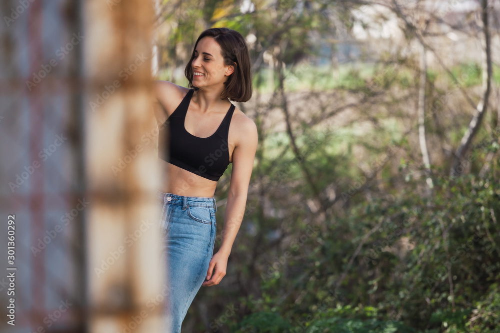 Young woman skater grabs ancient metal fence freedom concept Young woman skater grabs ancient metal fence freedom concept