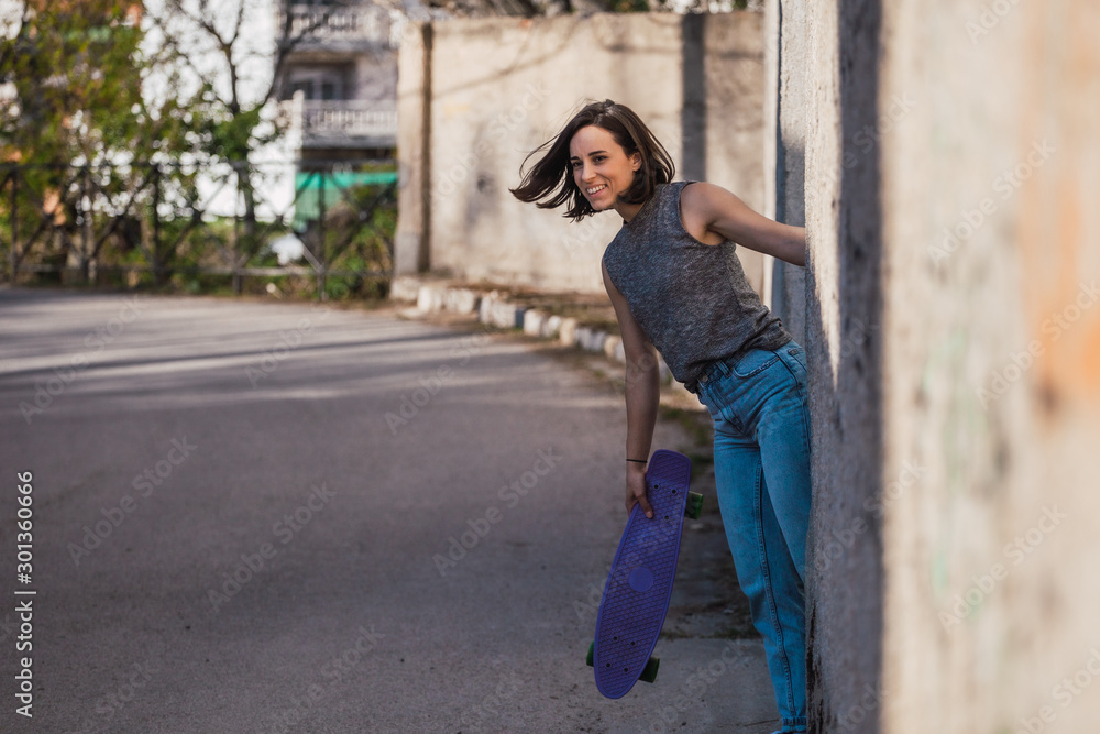 Young woman with blue penny skateboard in casual wearing