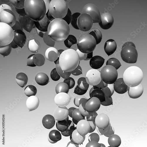 lots of balloons flying in the sky. monochrome, black and white