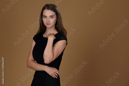 Girl in black dress on beige background
