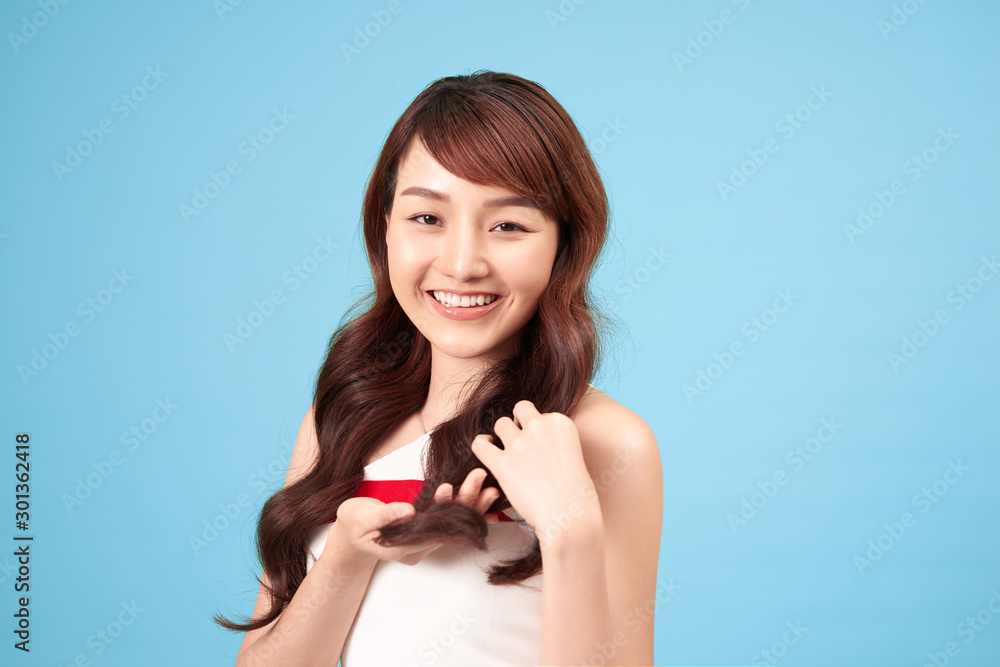 Asian woman smiling with long hair, isolated over blue background. Asian woman smiling with long hair, isolated over blue background.