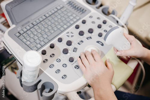 Doctors hands use an ultrasound medical device in a private clinic