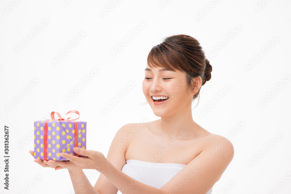 Happy young woman holding small gift box isolated on a white background Happy young woman holding small gift box isolated on a white background