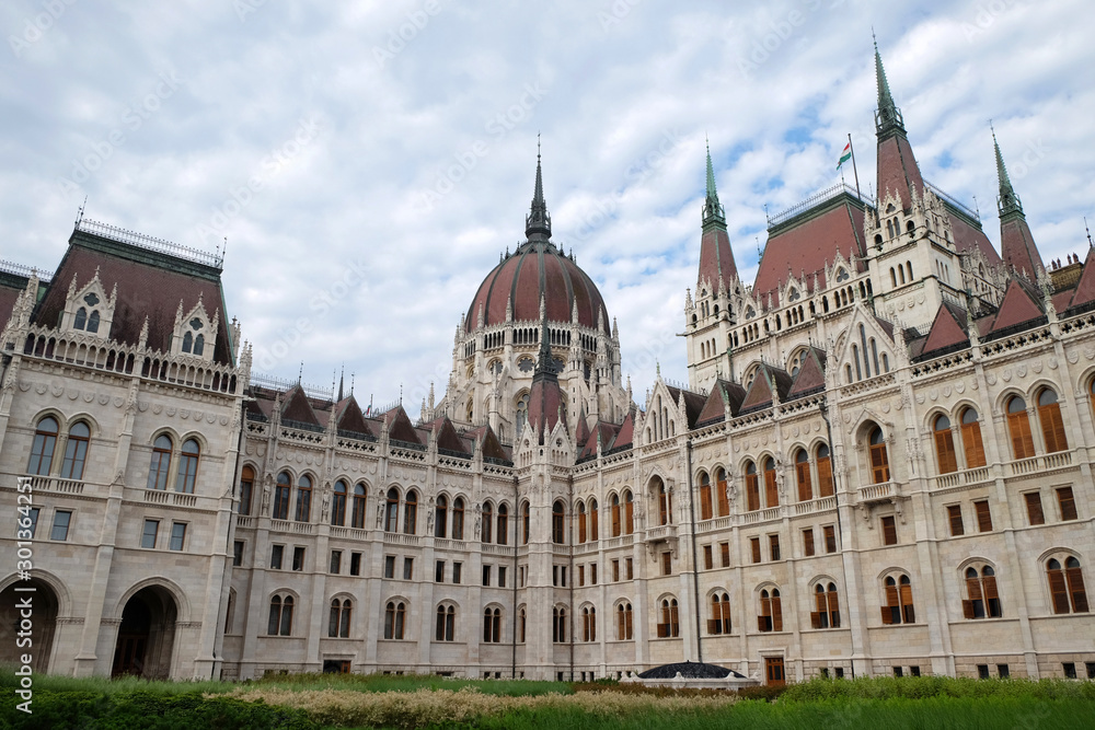 View of historical building of Hungarian Parliament in Budapest, Hungary, Europe on background of bright blue cloudy sky