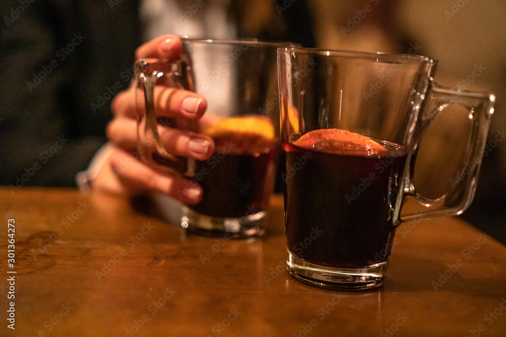 Beauty, elegant business woman with two glasses of mulled wine with orange and lemon inside the bar in basement. Wroclaw, Poland Beauty, elegant business woman with two glasses of mulled wine with orange and lemon inside the bar in basement. Wroclaw, Poland