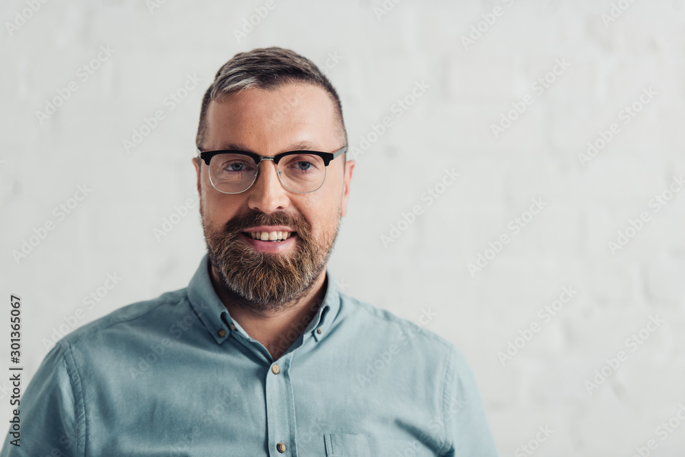 handsome businessman in shirt and glasses smiling and looking at camera handsome businessman in shirt and glasses smiling and looking at camera