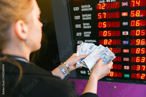Closeup of business woman with counting money. Woman hands counting turkish lira banknotes against the background of a currency exchange scoreboard. Counting or spend money