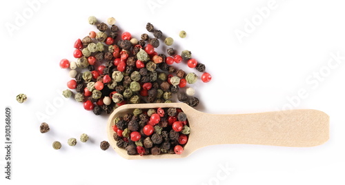 Colorful pepper pile in wooden spoon isolated on white background, top view