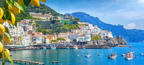 Leinwand Poster Panoramic view of beautiful Amalfi on hills leading down to coast, Campania, Italy