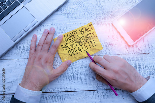 Text sign showing Don T Wait For Opportunity Create It. Business photo text work hard on yourself and begin from this moment Hand hold note paper near writing equipment and modern smartphone device