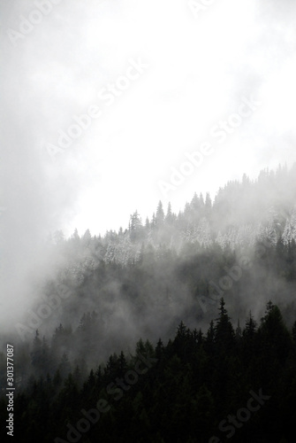 Italy, Trentino, Brenner Pass (Passo del Brennero): Dark, moody, faded aesthetic view on mountains in Tyrol with clouds, fog. Beauty in nature, Alps hills.