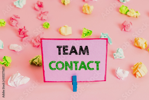 Writing note showing Team Contact. Business concept for The interaction of the individuals on a team or group Colored crumpled papers empty reminder pink floor background clothespin © Artur