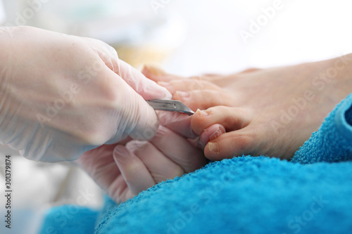 Clipping toenails. Woman s feet during pedicure  the beautician cuts cuticles and cuts nails with clippers.