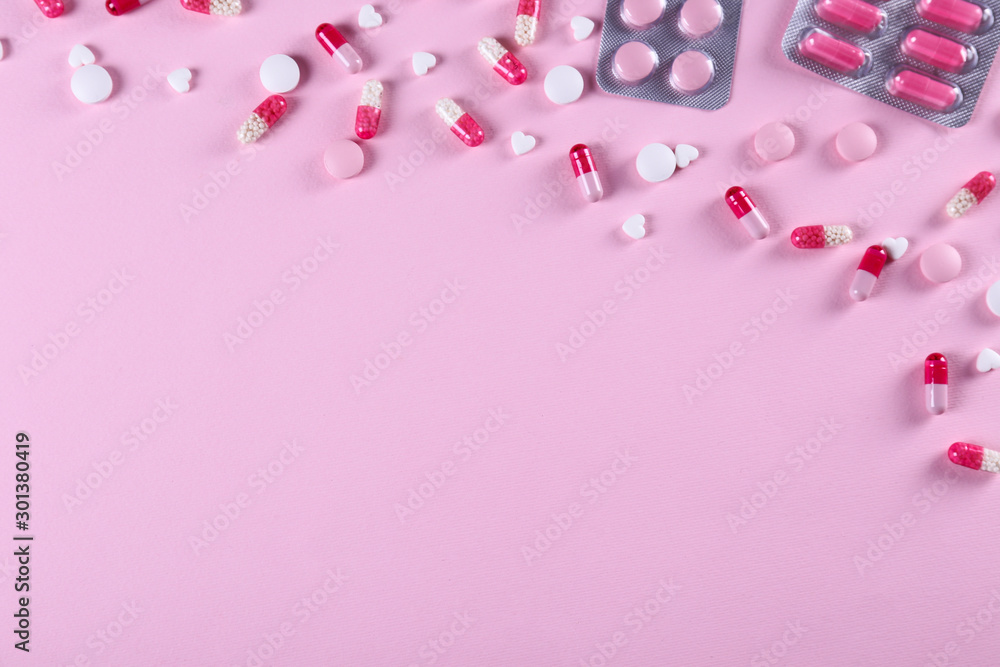 Flat lay composition with bunch of different colorful pills in blister packs. Pile of unpacked medication on paper textured background. Close up, copy space.