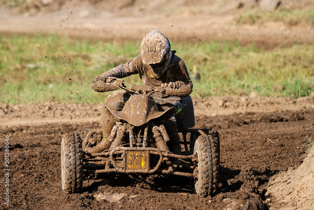 Motocross quad race with races who are covered with mud in an old motocross track. Motocross quad race with races who are covered with mud in an old motocross track.
