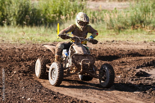 Fototapeta Naklejka Na Ścianę i Meble -  Motocross quad race with races who are covered with mud in an old motocross track. 
