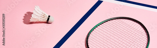 Badminton racket and shuttlecock on pink background with blue lines  panoramic shot