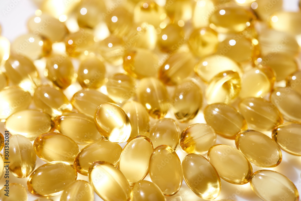 close up view of shiny golden fish oil capsules close up view of shiny golden fish oil capsules
