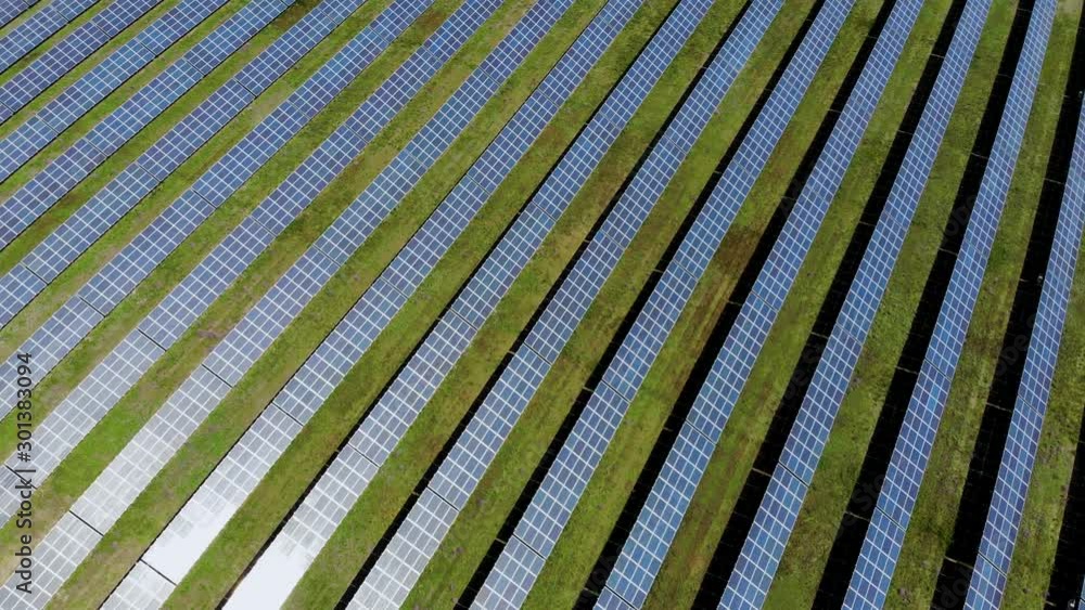 Aerial flying over a huge solar power plant producing ecological