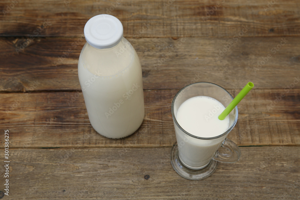 bottle of organic milk and glass of milk on the wooden rustic background with copy space for text. Dairy products. bottle of organic milk and glass of milk on the wooden rustic background with copy space for text. Dairy products.
