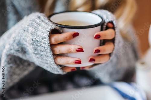 a warm tea to heat a cold winter. The girl is holding herbal tea. a cup of linden tea