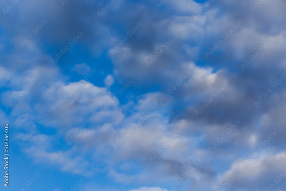 Naklejka premium Beautiful white clouds on a background of blue sky. Defocused image for design.