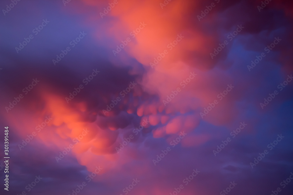Unusual pink-purple mammatus clouds at sunset. Blurred image for backgrounds.