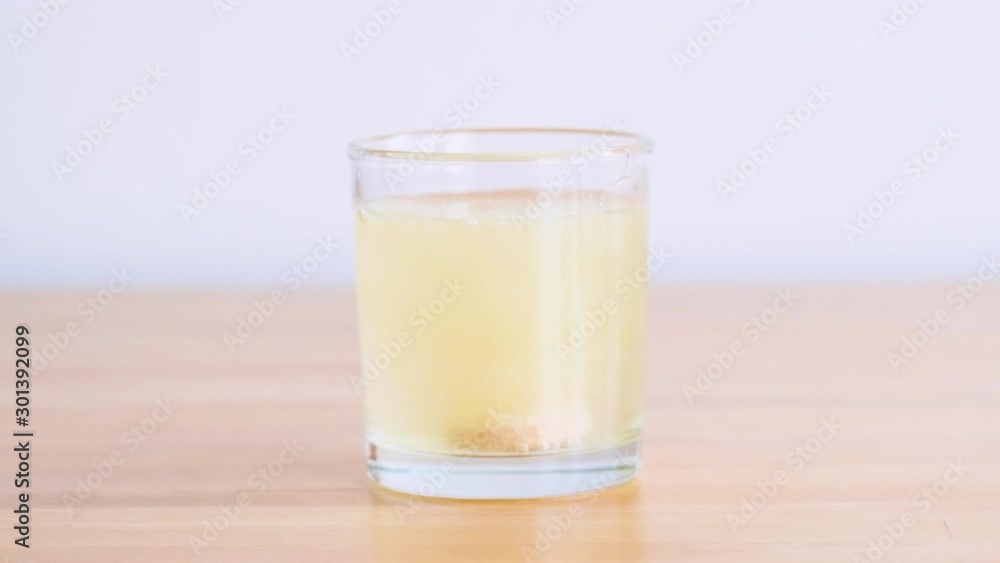orange effervescent vitamin in tablet thrown into a glass with water orange effervescent vitamin in tablet thrown into a glass with water