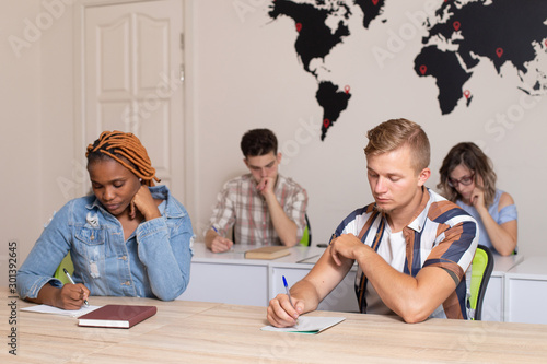 Fotografija Group of international students in classroom with world map on the wall on background