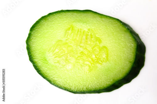 Ripe green cucumber on slices on a white background