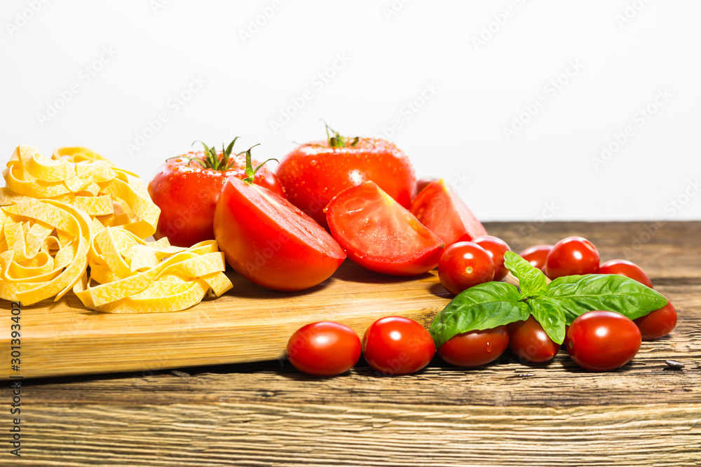 TOMATOES ON A BOARD WITH BASIL AND SPICES TOMATOES ON A BOARD WITH BASIL AND SPICES