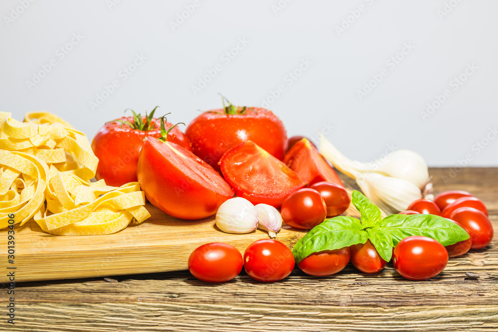 TOMATOES ON A BOARD WITH BASIL AND SPICES TOMATOES ON A BOARD WITH BASIL AND SPICES