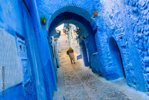 A traditional dressed moroccan woman walks in the old town (medina) of Chefchaouen in Morocco. © Rosa Frei