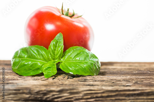 TOMATOES ON A BOARD WITH BASIL AND SPICES