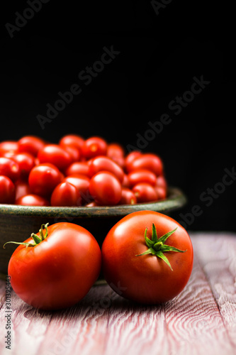 CHERY TOMATOES ON A BLACK BACKGROUND WITH SELECTIVE FOCUS