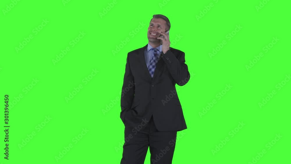 Happy caucasian businessman making a phone call while standing in the studio. Shot in 4k resolution with green screen background Happy caucasian businessman making a phone call while standing in the studio. Shot in 4k resolution with green screen background
