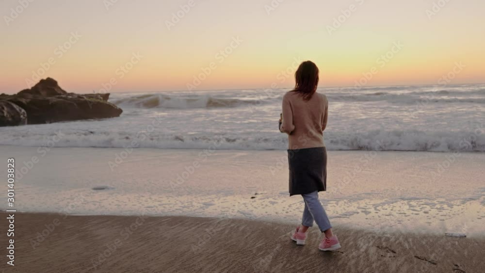 Woman enjoying hot drink on a sunset near ocean Woman enjoying hot drink on a sunset near ocean
