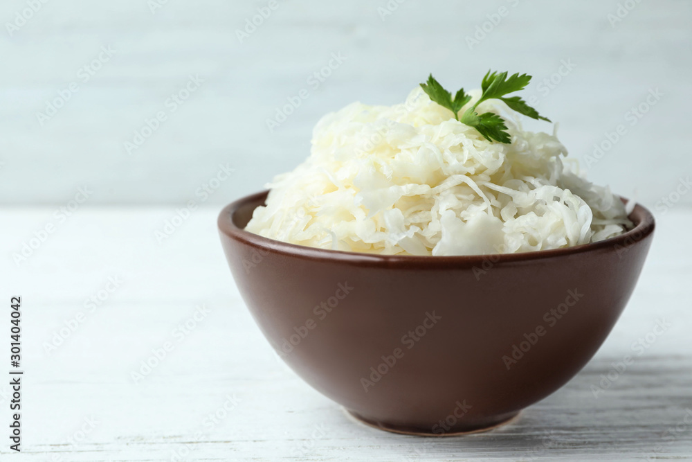 Tasty fermented cabbage on wooden table, closeup Tasty fermented cabbage on wooden table, closeup