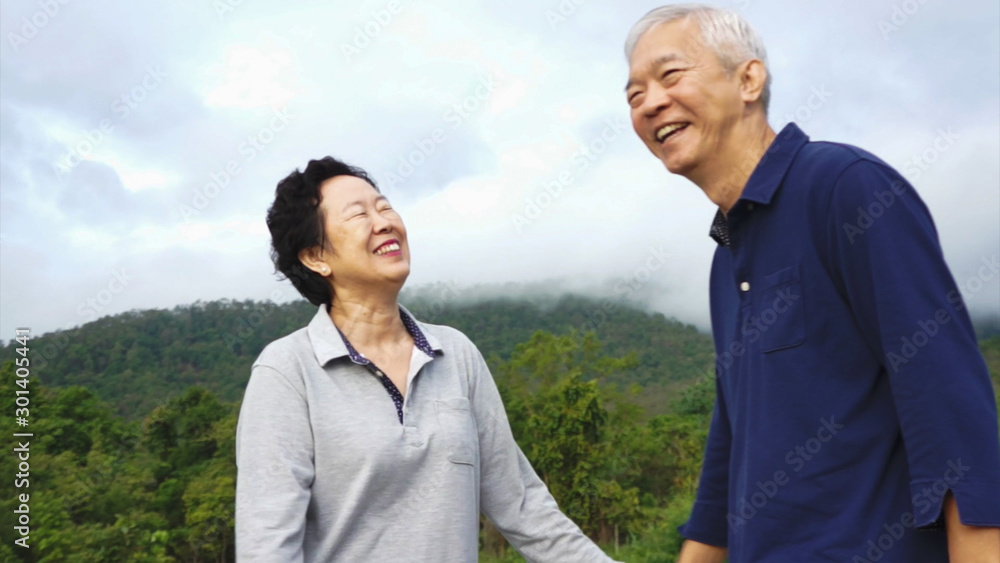Asian elder couple laughing while nature mountain trekking exercise Asian elder couple laughing while nature mountain trekking exercise