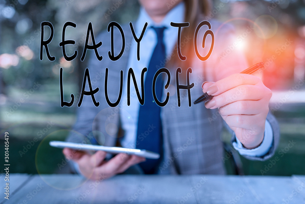Writing note showing Ready To Launch. Business concept for an event to celebrate or introduce something new to market Female business person sitting by table holding mobile phone Writing note showing Ready To Launch. Business concept for an event to celebrate or introduce something new to market Female business person sitting by table holding mobile phone
