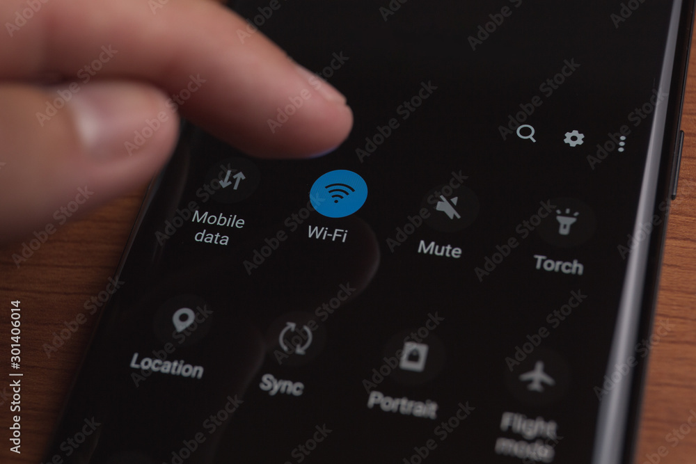 close up of male hand enabling wireless connection in smartphone close up of male hand enabling wireless connection in smartphone