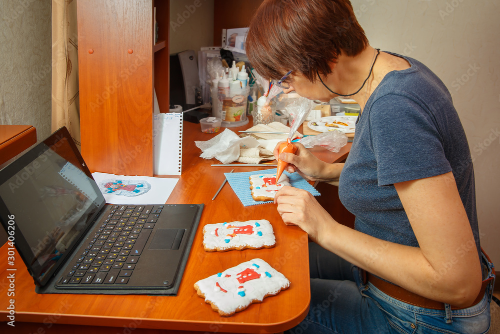 A young girl is engaged in decorating gingerbread cookies. A young girl is engaged in decorating gingerbread cookies.