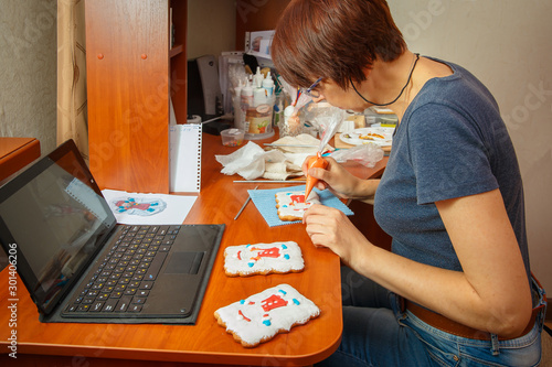 A young girl is engaged in decorating gingerbread cookies.