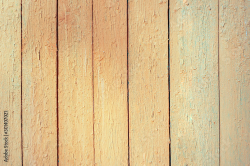 Wooden brown and yellow background of vertically arranged narrow boards. Background with bright  peeling paint. The surface of the table top view