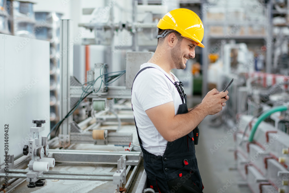 Factory worker in uniform with phone Factory worker in uniform with phone