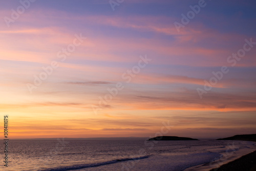 Beach with pink sunset and headland 