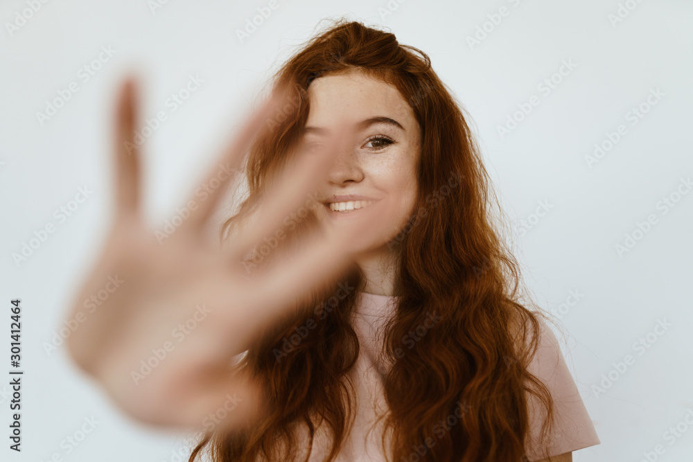 red-haired brown-eyed beautiful girl with a smile makes a prohibitory gesture with his hand, pushing away the camera red-haired brown-eyed beautiful girl with a smile makes a prohibitory gesture with his hand, pushing away the camera