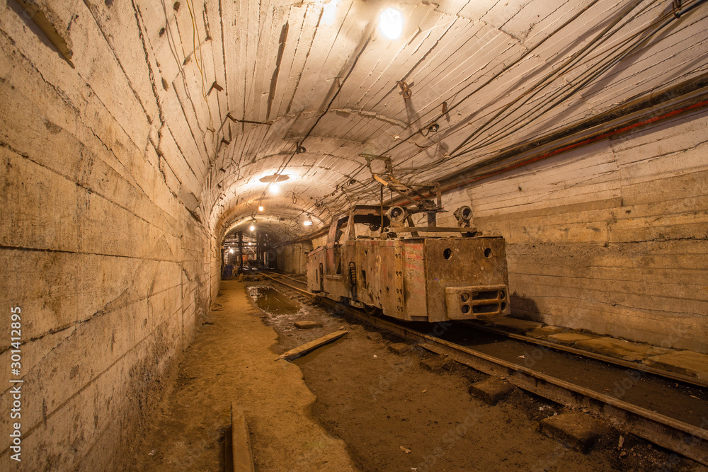 Gold iron mine ore shaft tunnel drift with rails electric locomotive