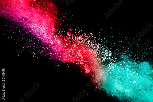 Red green powder explosion on black background.Red green dust particles splash.