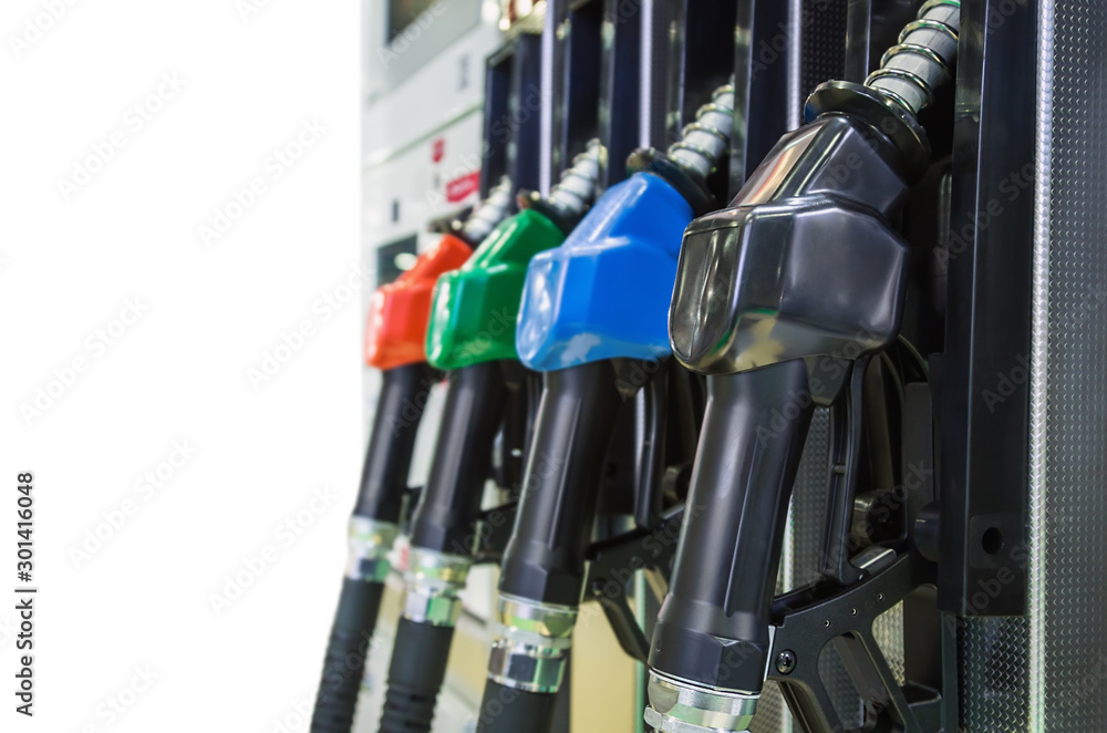 Pump nozzles at the gas station isolated on white background. Shallow depth of field with focus on nozzle red Pump nozzles at the gas station isolated on white background. Shallow depth of field with focus on nozzle red